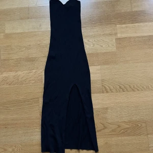 Svart tight klänning - Svart, tight klänning. Ribbad med slit över ena benet. Storlek XS. Skulle säga att den är stor i storleken. Aldrig använd.