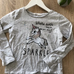  en lång armad liten tröja  -  En grå liten fin långärmad tröja med en enhörning på 🦄