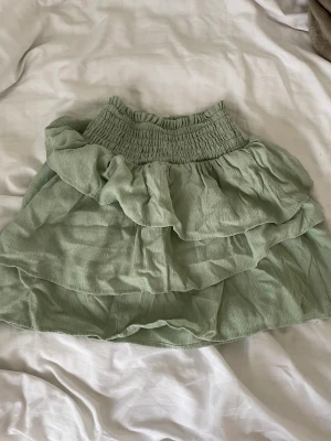 Grön volang kjol - En ljus grön kjol, passar till sommaren. Storlek 158/164 men skulle säga att den passar mer som 147/152. Passar också för de som gillar Stockholm stil👍🏼