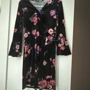 Klänning - Velour klänning med blommig mönster köpte från H&M. Passar till Jul och andra tillfällen. Normal i storlek och i my let bra skick. Använd bara 2 gånger.  