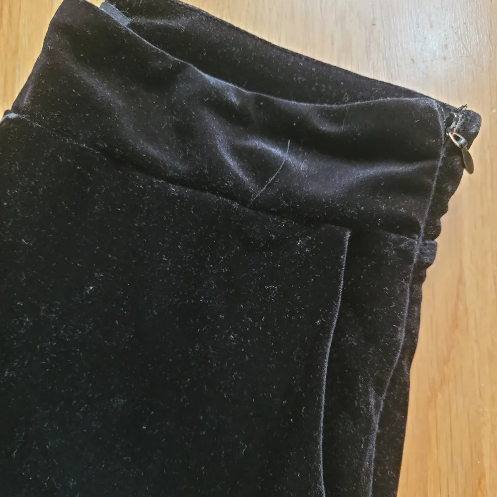 Svarta, lite kortare sammetsbyxor med fickor, dragkedja på sidan och lite vida ben. Tyget är lite nött på några ställen. 100 cm långa.. Jeans & Byxor.
