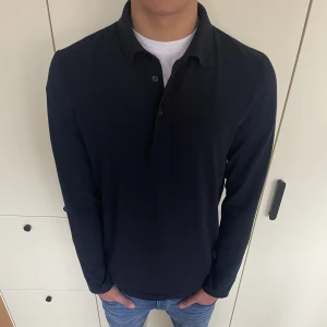 Långärmad piké - En mörkblå långärmad piké från Filippa K. Nypris är runt 900kr och den är i princip helt oanvänd. 