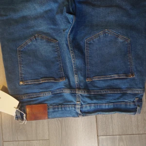 Nya Lindbergh jeans i 33/34 och stretch kvalitet  - Helt nya Lindbergh jeans i snygg mörkblå färg med snygg design slitningar och stretch kvalitet Org prislapp på 600 kr sitter kvar  Mitt pris 199 kr plus frakt 