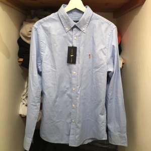 Snygg ljusblå Ralph Lauren skjorta, helt oanvänd. Nypris: 1400 kr. Skriv gärna om du har några frågor!