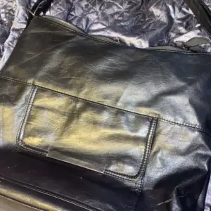 En svart väska som är väl använd men är i ett bra skick.  