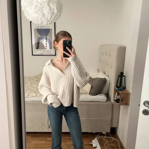 Stickad tröja - Ljust beige stickad tröja med v-ringning. Använd fåtal gånger. Säljer pga kommer ej till användning. Från weekday i storlek M. Nypris 500kr