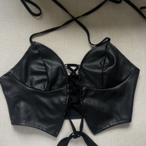 Skinn korsetttopp - En super snygg skinn topp, men snörning fram så man själv kan bestämma hur tajt man vill ha den. Säljer pga av att jag har 2 likadana, så denna är helt oanvänd. Bra kvalité & supersnygg😍 fler bilder kan skickas privat. (Köparen står för frakt) 