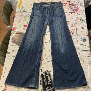 Vida lågmidjade jeans - Ett par favorit jeans som man kan se på slitagen men de har tyvärr blivit för små. De är extra vida i benen som är väldigt år 2000. Midjemått, raktöver: 37cm. Innerbensmått: 81cm. 