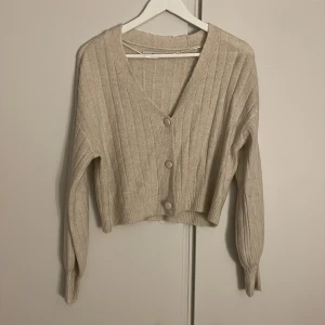 Kofta - En stickad kofta perfekt nu i vinter. Den har en crémevit färg och kan antingen bäras knäppt eller öppen. Den är i mycket bra skick! Köpt på veromoda.