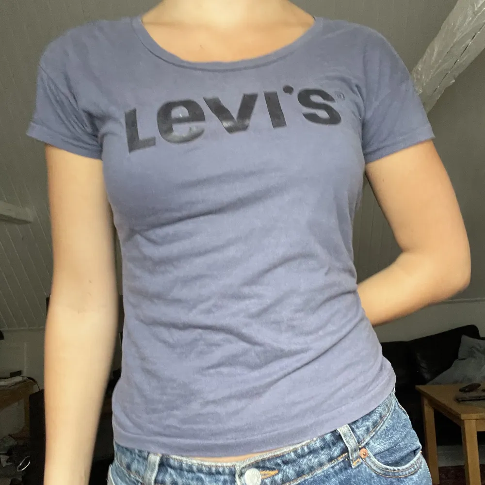 T-shirt från Levis i strl XS. Mörkblå/grå med svart glansigt tryck. 💝. Toppar.