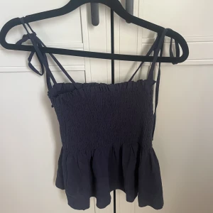 Blå topp - Blå söt topp som går ut nedtill, justerbara axelband.