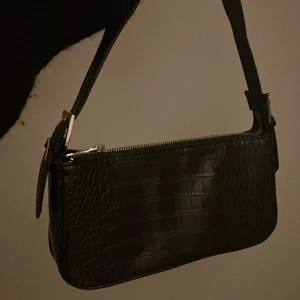 axelremsväska - säljer min svarta axelremsvöska ifrån gina tricot eftersom den aldrig används, får plats med mycket i!
