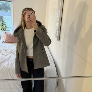 Vinterjacka  - Kort grå kappa från Zara. Den har en luva och två ytterfickor. Väl omhändertagen. Knappt använd. Pris går att diskutera vid snabb affär 💕 Lånade bilder från en tjej och hon är 174cm, jackan är 62cm från framsida axel ner💗  