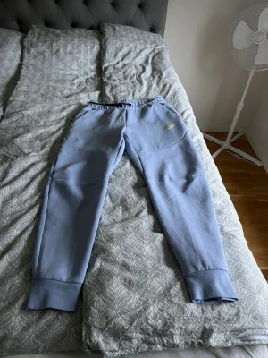 Nike tech byxor  - Ett par helt nya tech byxor i en väldigt fin ljusblå färg. Köpte ett sett med Hoodie men byxorna var tyvärr lite för små, men som sagt helt nya. Nypris är 1249kr 