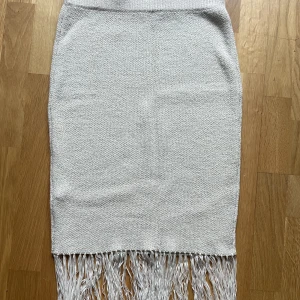 Stickad kjol  - Stickad kjol i storlek small. Cremevit med fransar. 