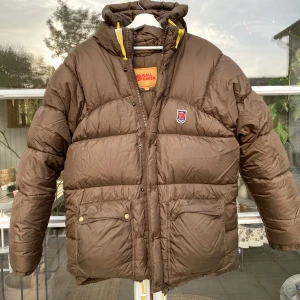Fjällräven expedition vinter dunjacka  - Hej, säljer min tjejs bruna vinterjacka från Fjällräven. Storlek S och passar olika beroende på storlekspreferens. Jackan är i bra skick men har några defekter, bild på det i DM. Nypris 8000kr. Varm & skön, perfekt inför vinter. Pris kan diskuteras. Hörs!