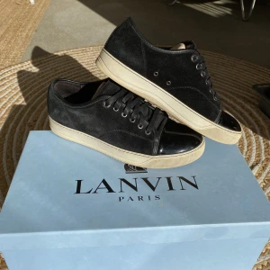 Lanvin Patent Cap Toe Sneaker Black - Hej, säljer ett par populära och snygga svarta Lanvin Patent Cap Toe Sneakers. Size 5 vilket motsvarar 40/40,5. Nypris 4600kr. Box medkommer vid köp.  Helt nya snören. Använda men i bra skick, fler bilder kan fås i DM. Pris kan diskuteras. Hör av dig. 