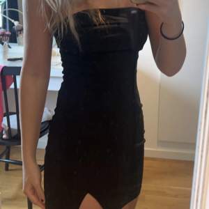 Säljer en helt oanvänd svart klänning utan axlar i storlek S 