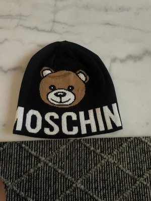 Moschino mössa  - Säljer min moschino mössa då jag aldrig har haft den till användning. Taggen på mössan finns kvar, skriv för fler bilder.
