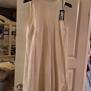 Halvt stickad klänning - Klänningen är oanvänd. Den är stickad fram men inte bak.