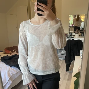 Meshtopp - Nästan genomskinlig (mesh) blus med detaljer vid handleder