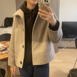 Kappahl kappa - Beige kort kappa från Kappahl i ljusbeige färg. Slutsåld och går ej att få tag i på hemsidan. Sparsamt använd så har inga märken på användning. Nypris 900. Passar S-M. 