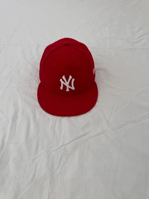 Röd New Era Keps - Röd New Era keps i storlek 7 1/8 (56.8cm). Otroligt fin och endast använd ett fåtal gånger då jag beställde fel storlek :( meddela för mer information eller frågor, KÖPAREN STÅR FÖR FRAKT! 