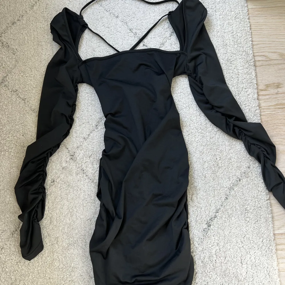 Säljer denna supersnygga svarta klänning. Säljer på grund av att jag ej har anvöndning av den. Klänningen är i storlek xs och den har en öppen rygg med snörning.. Klänningar.