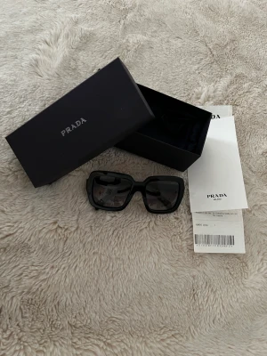 Prada solglasögon - Helt nya PRADA solglasögon köpta i italien, använda enstaka gånger. Säljer då de ej kommit till användning. Låda, fodral och kvitto medföljer. Påsen finns också om man vill ha.