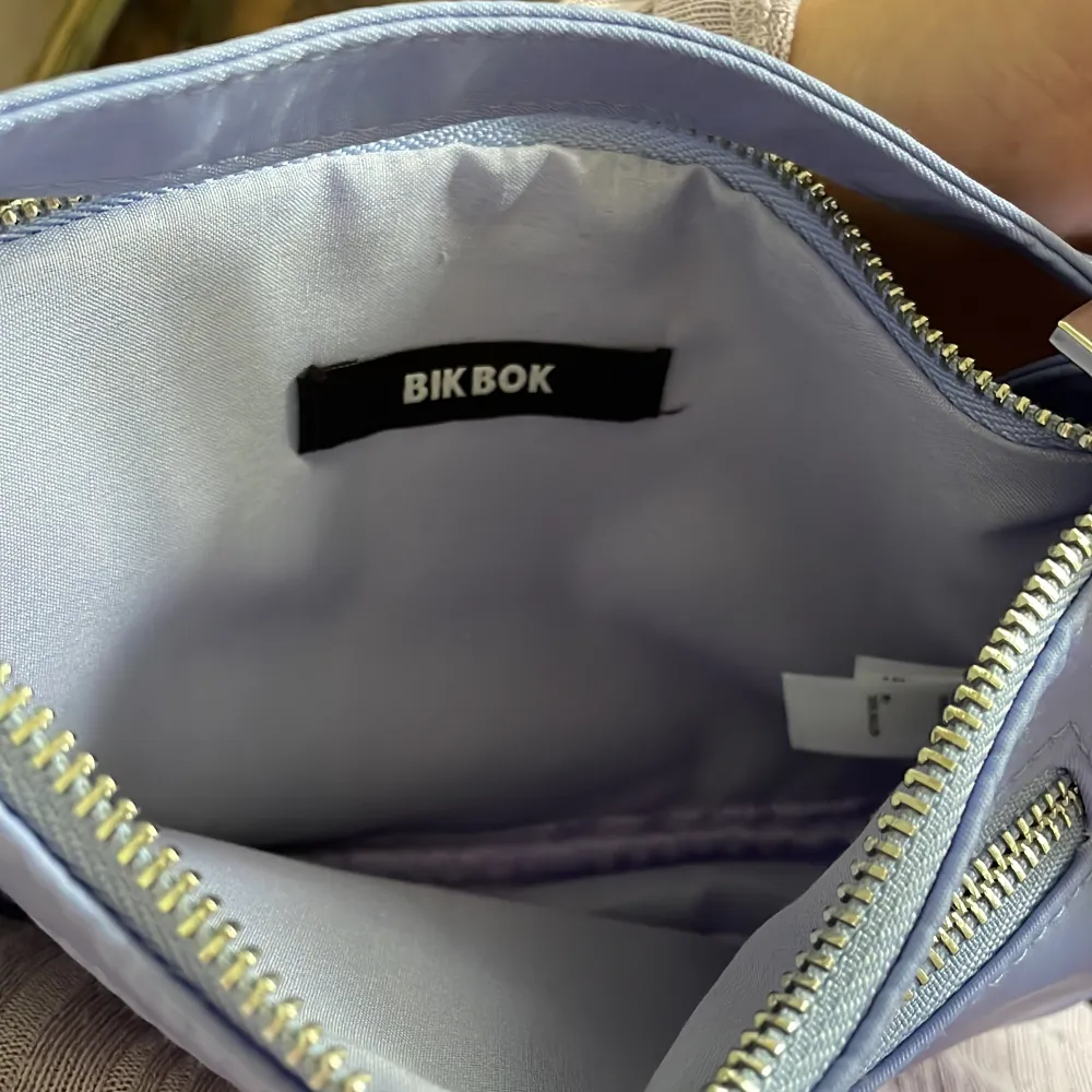 En fin liten ljuslila kuvertväska från BikBok med ett extra fack på utsidan. Knappt använd!. Väskor.