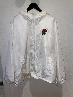 Vit vindjacka  - Vit vindjacka i nyskick, säljer då den aldrig används. Storlek L men sitter som M. 