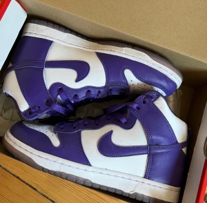 Nike Dunks - Höga Nike Dunks, vit/lila.  Storlek: 38,5.  Använda en gång så i fint skick. Originalkartong medföljer.