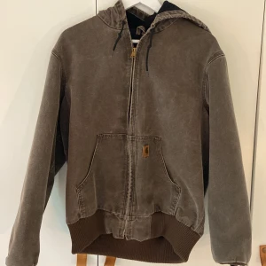 CARHARTT DENIM HOODIE JACKA - Brun carhartt denim jacka Jättebra skick, knappt använd, köpt för ett år sedan. Inga större fläckar, den enda är bild 2.
