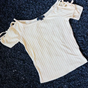 Gul topp med snörning - Fin gul topp med snörningsdetaljer i ärmarna. I ny skick.