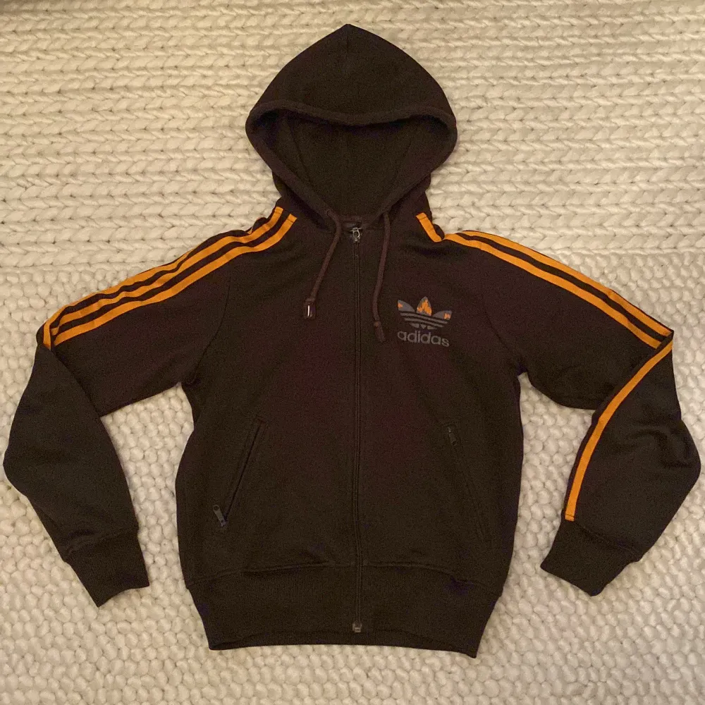 Säljer en snygg adidas track hoodie som är brun med orangea streck🤎Frakt står du för själv!💕. Hoodies.