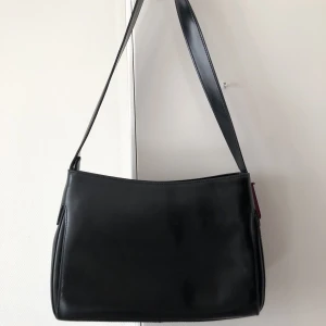 Handväska - Säljer denna svarta läderhandväska. Inköpt på vintagebutik, i något italienskt märke. Superfint skick! Ca 30x15 cm