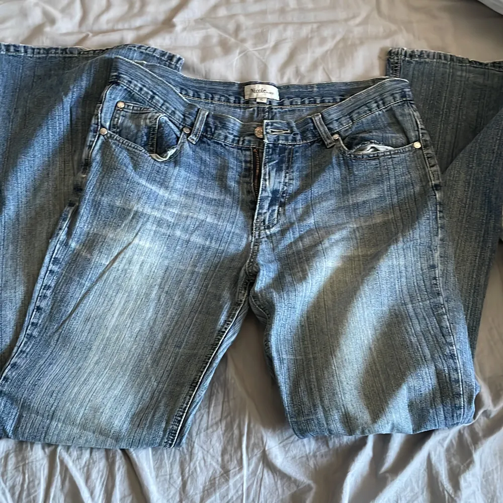 Mid waist jeans i S/M  midjemått: ca 90cm de är lite trasiga på baksidan långt ned på låret men det är sytt igen (se sista bild) därav ser det ut som ett litet kors. Jeans & Byxor.