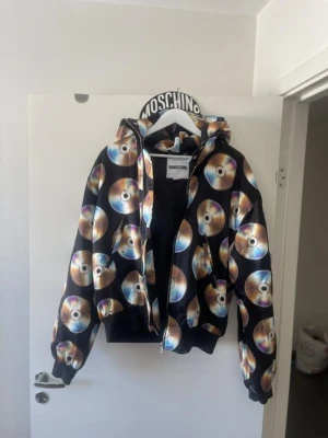 H&M x Moschino kollektion - Stl. 40 (M) Oanvänd H&M x Moschino jacka st M. Jag skulle säga att denna är för/passar både tjej och kille. 