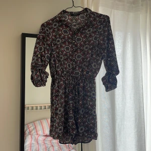 Byxdress från New Look - Jättefin byxdress med flowy material, knäppning upptill och snörning i midjan Modellen är ”petite” UK storlek 8 som motsvarar en S