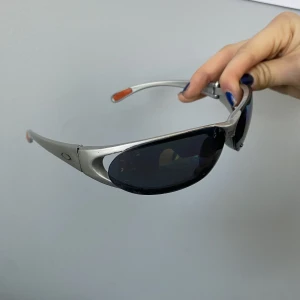 Trendiga vintage solglasögon  - Coola brillor från oakley. Funkar Unisex! Vintage y2k stil. Silvriga med reflekterande glas. Ena glasögon bågen är lite slapp, men de funkar felfritt! 
