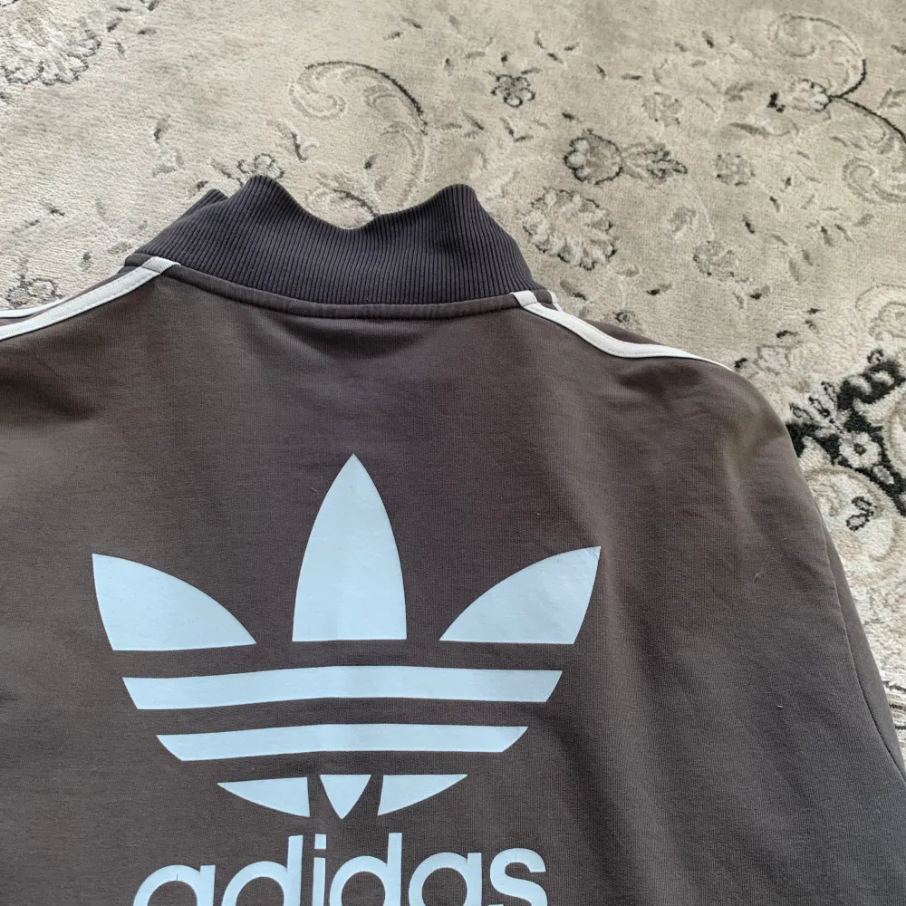 en grå tunn adidas zip up perfekt till sommaren. loggan är ljusblå. storlek XL men passar mer som M eller L. Den ända defekten är att ”Adidas” loggan på blixtlåset gick sönder men det går att knäppa hoodien utan problem. skriv privat för mer info💕. Hoodies.