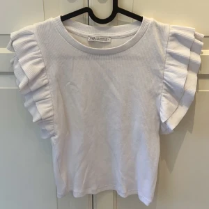 Vit volangtopp  - Säljer denna vita volangtopp från Zara som är perfekt inför sommar och vår! Toppen är i storlek M men liten i storlek💕Nyskick och säljer för 50kr+ frakt🤍
