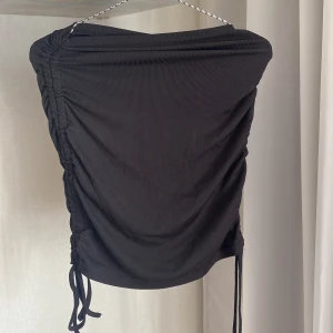 Kjol  - Svart kjol från SHEIN i storlek S med snören på sidorna, kjolen går att förlänga och förkorta. Använd någon enstaka gång förra sommaren! Nypris 79kr