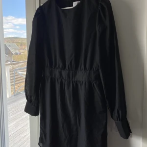 Svart klänning - Svart oanvänd klänning med prislapp kvar! Storlek 38 från NA-KD!