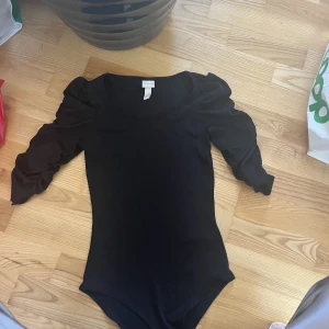 Body - Oanvänd body med puffigare ärmar, bodyn är i ett så skönt strechigt matrial