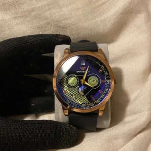  Emporio Armani klocka  -  Exklusiv och unik Klocka Väldigt svår att få tag på med ett unikt och snyggt glas som går upp i kristallform klockan har ett gummiband och är i roseguld runtom