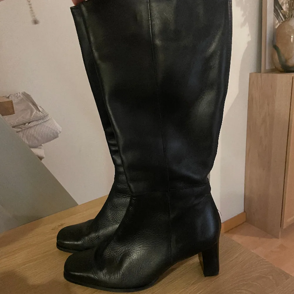 Klack boots i skinnimitation, slutar precis nedanför knäna.. Skor.