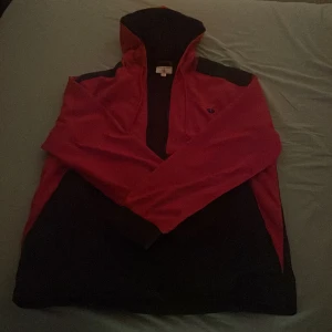 Truey jacka mesh - En truey jacka röd och svart med ett mesh material på insidan.