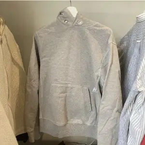 En grå Helmut Lang hoddie ,HL tryck utgående kollektion , skick 8/10 , Strolek M, Inga hål fläckar eller liknade, hör av dig vid frågor