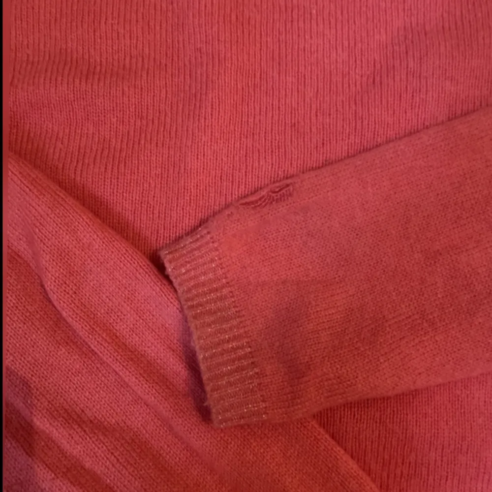 En så fin charsmire tröja i en rosa röd färg med glittriga ärmar ner till. Den kommer från costercopenhagen och är i storlek XS. Den har lite släppningen i sömen under armarna men inget man tänker på alls, det går att sy till också.. Stickat.